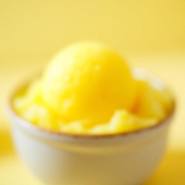Bright yellow scoop of lemon sorbetto.