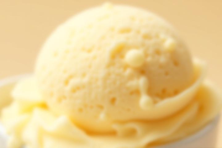 Extremely creamy vanilla bean ice cream scoop, glistening with richness.