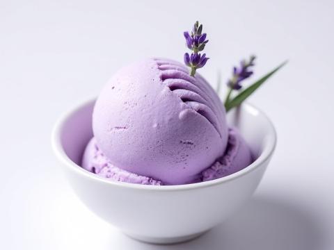 Scoops of pale purple Lavender & Honey ice cream in a white bowl, garnished with a sprig of fresh lavender.